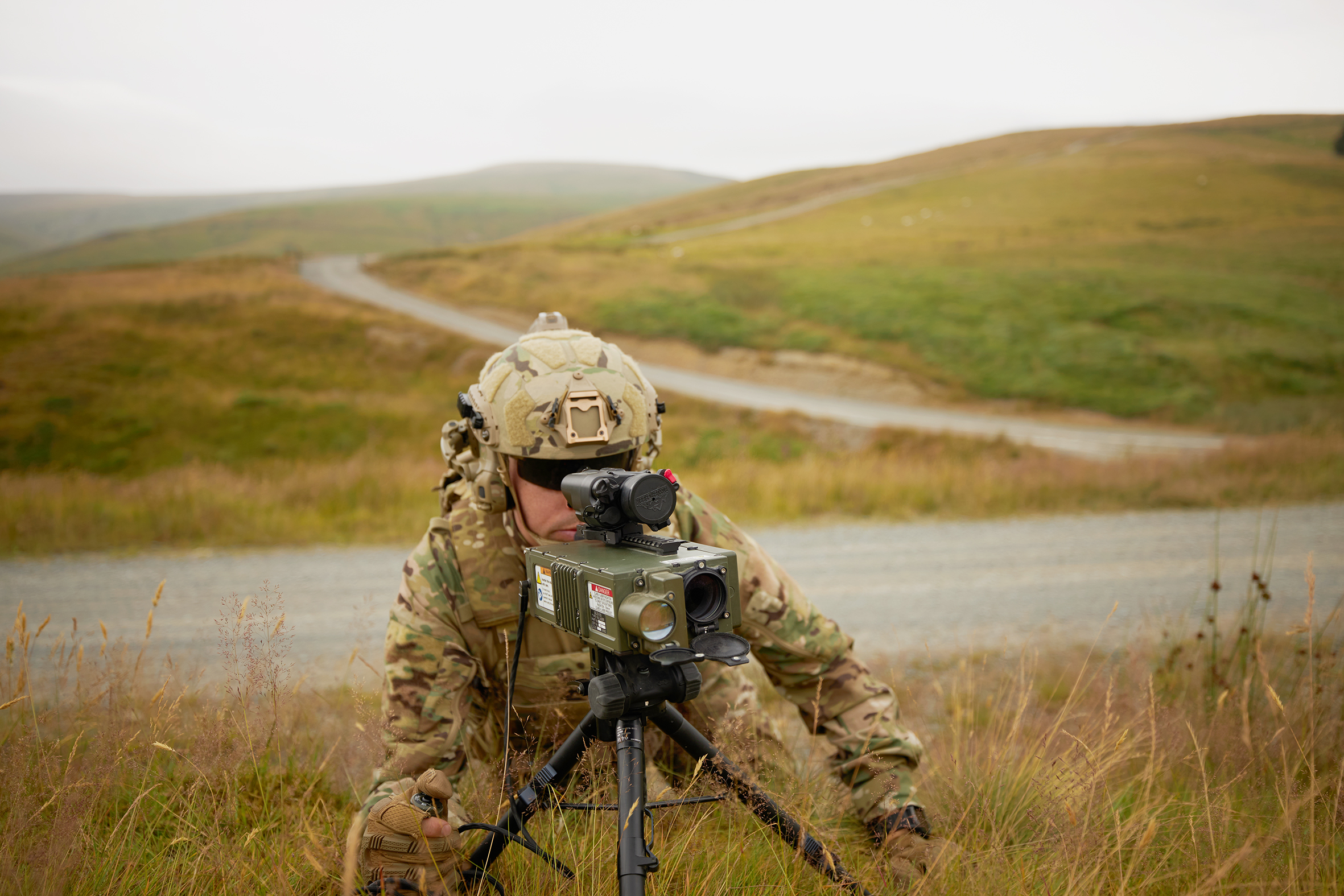 Soldier operating integrated surveillance and targeting equipment in the field