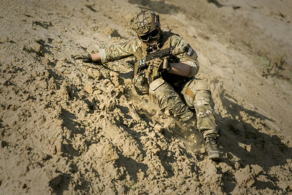 Soldier in integrated tactical equipment operating in challenging terrain