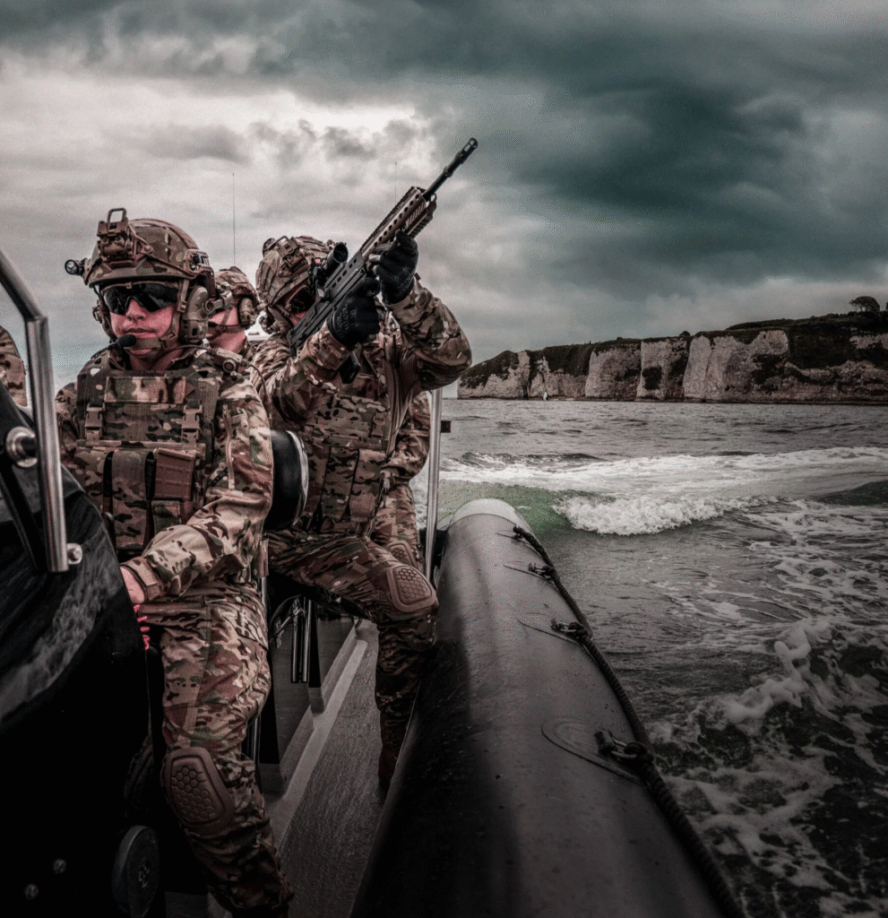 Modern soldiers equipped with integrated soldier systems conducting amphibious military operations from a rigid inflatable boat.