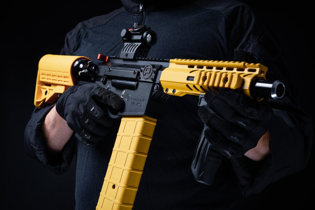 Officer holding PepperBall non-lethal launcher for tactical law enforcement operations